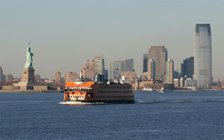 a ferry boat in the water with Staten Island Ferry in the background