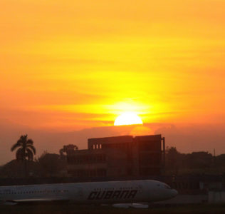 an airplane on the runway at sunset