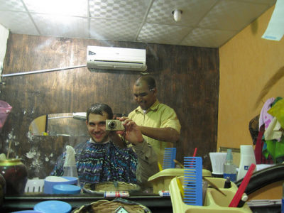 a man taking a picture of a man in a barber shop