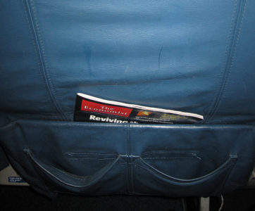 a magazine in the pocket of a blue chair