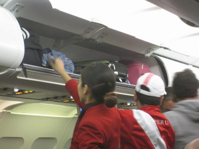 people in a plane with luggage