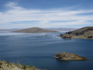 a body of water with land and hills in the background