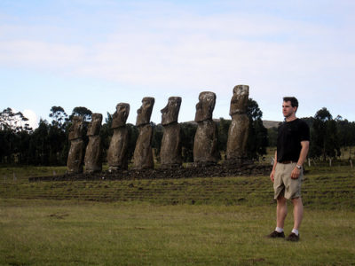 a man standing in front of a row of statues