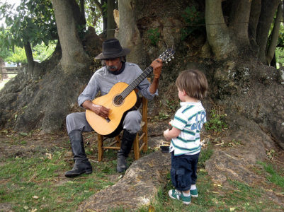 a man playing a guitar with a young boy