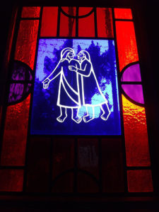 a stained glass window with a picture of two women