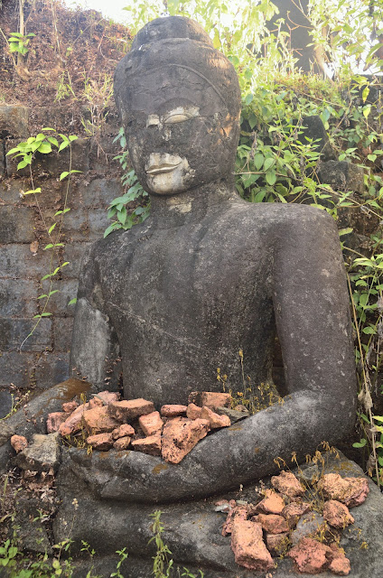 a stone statue of a man holding bricks
