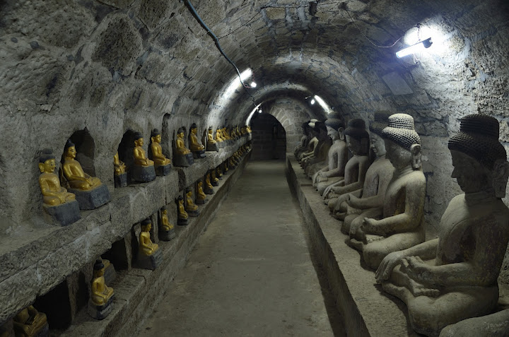 a row of statues in a tunnel
