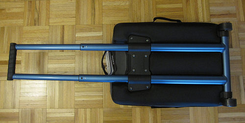 a black suitcase with blue handles