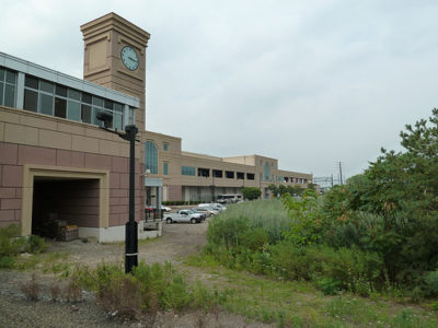a building with a clock tower and cars parked in front of it