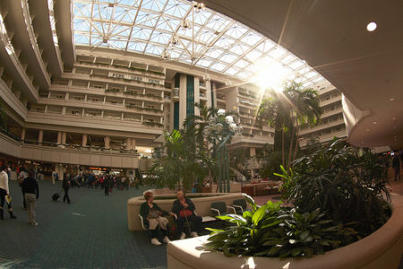 people sitting in a lobby with a large building and a large skylight