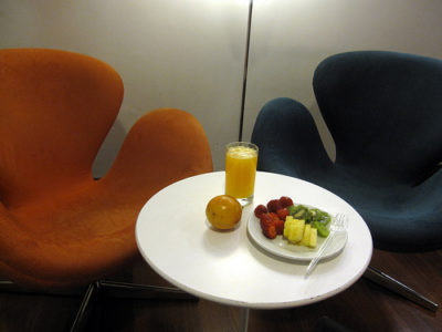 a plate of fruit and a glass of juice on a table