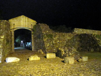 a stone archway with stone walls and stone benches