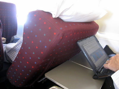 a person using a laptop on an airplane seat
