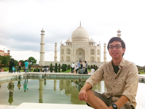 a man sitting in front of Taj Mahal