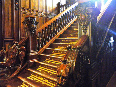 a wooden staircase with carved wood railings