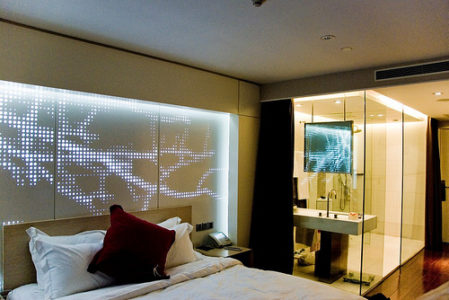a bedroom with a glass wall and a bed
