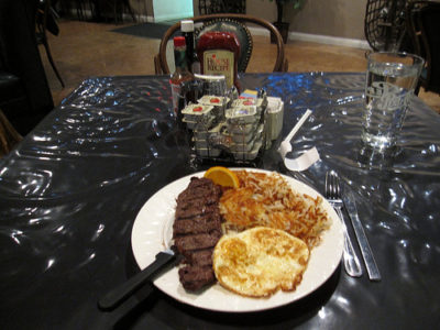 a plate of steak eggs and eggs on a table