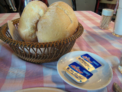 a basket of bread and cheese on a plate