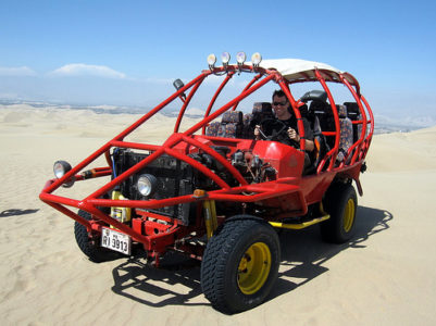 a man driving a red vehicle in the desert