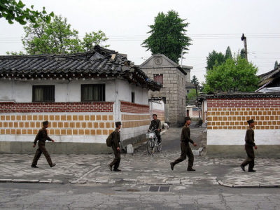 a group of men in uniform walking in the street