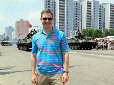 a man standing in front of a military vehicle