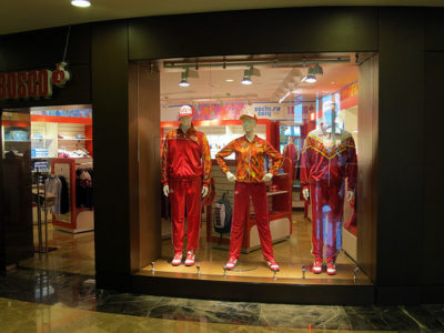 a storefront with mannequins in red tracksuits