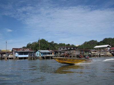 a boat on water with houses in the background