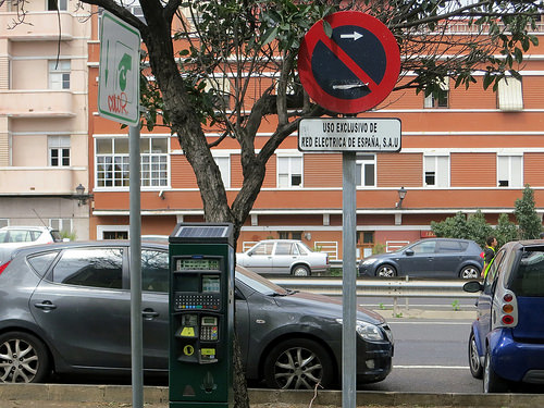 a parking meter and a sign on a street