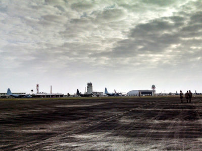 a runway with planes in the background