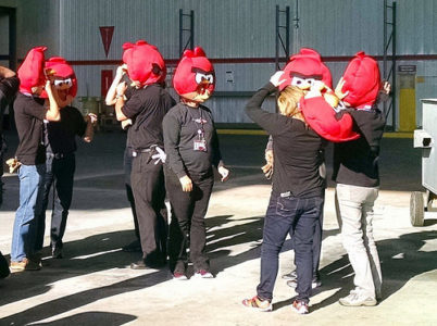 a group of people wearing red angry birds masks