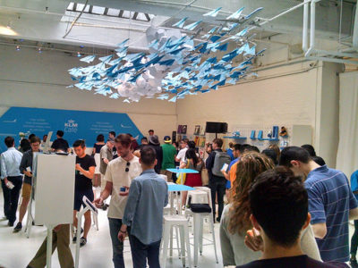 a group of people in a room with paper airplanes from the ceiling