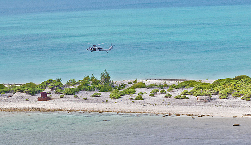 a helicopter flying over a beach