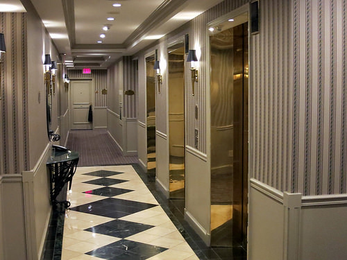 a hallway with elevators and a checkered floor