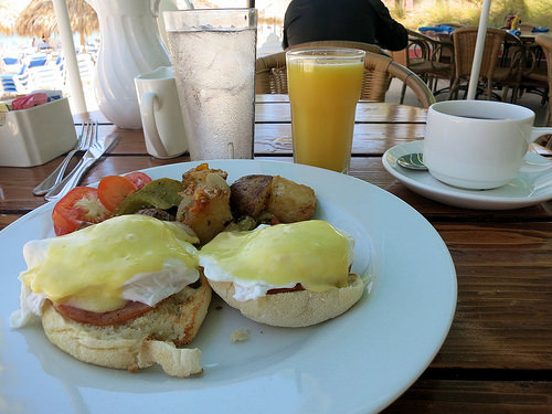 a plate of eggs benedict and a drink