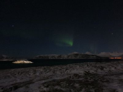 a green lights in the sky over a snowy landscape