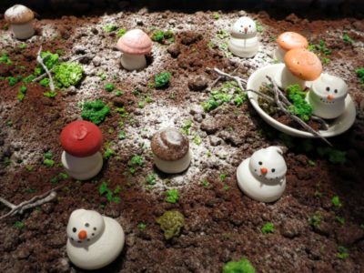a snowman and mushrooms on dirt